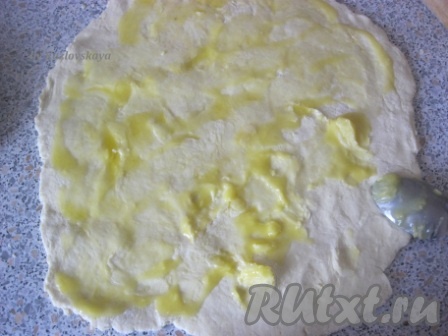 Раскатать тесто на присыпанной мукой поверхности. Намазать оставшимся растопленным маслом.
