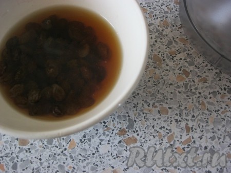 Изюм промыть, удалить веточки, залить 2 столовыми ложками рома или крепким чаем минут на 30.
