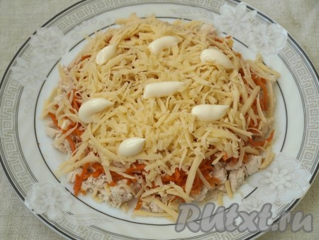 На тёрке натереть твёрдый сыр, посыпать его поверх моркови и нанести майонез.