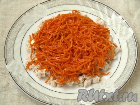 Сверху курицы выложить морковь по-корейски. Майонезом смазывать не нужно, так как этот слой очень сочный.