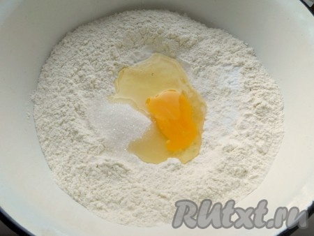 Муку просеять в глубокую большую миску. Сделать углубление, добавить яйцо, соль и сахар и разрыхлитель.