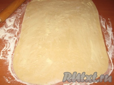 Охлажденное тесто раскатать в пласт толщиной 1 см, смазать поверхность половиной размягченного масла.
