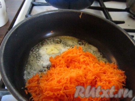 Пока картофель варится, очистите и натрите на тёрке морковь. В глубокой сковороде растопите кусочек сливочного масла и слегка обжарьте на нём тёртую морковь.
