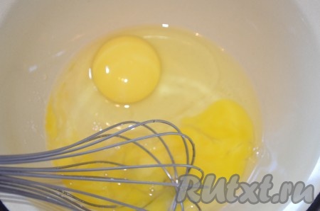 В миску разбить яйца, венчиком перемешать с солью и сахаром.