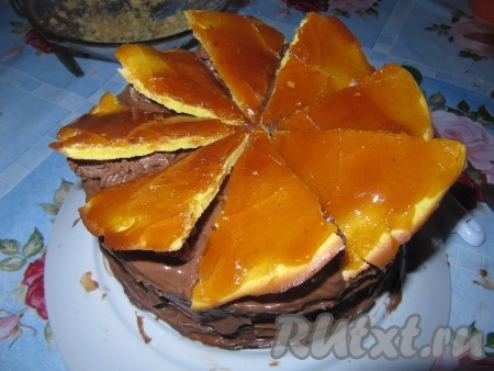 Завершите украшение торта "Добош", расставив треугольники с карамелью между кремовыми розочками.

