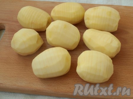 Картофель следует выбирать для этого рецепта правильной формы и одинакового размера. Картошку помыть и очистить. По всей поверхности картофеля сделать поперечные надрезы на 2/3 толщины, то есть не разрезая клубень до конца.