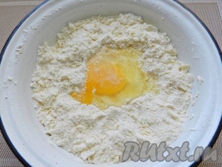 Для приготовления теста охлажденное сливочное масло натереть на терке, смешать с мукой, разрыхлителем, солью и сахарной пудрой в однородную крошку. Добавить яйцо и замесить мягкое тесто.
