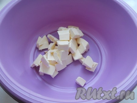 Масло холодное порезать небольшими кусочками в глубокую посуду.