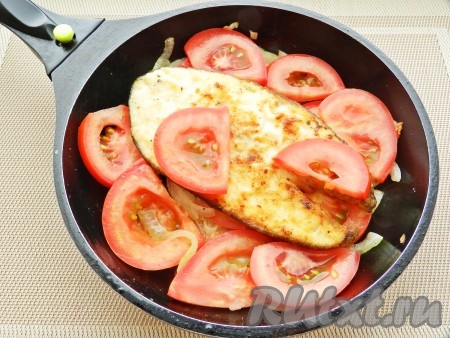 Выложить в сковороду к луку помидоры и рыбу, накрыть крышкой и готовить 15-20 минут.
