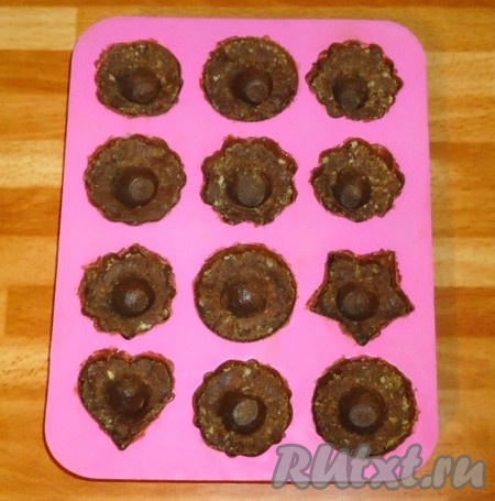 Формочки с шоколадом заполнить шоколадной массой из печенья, сделать углубления.
