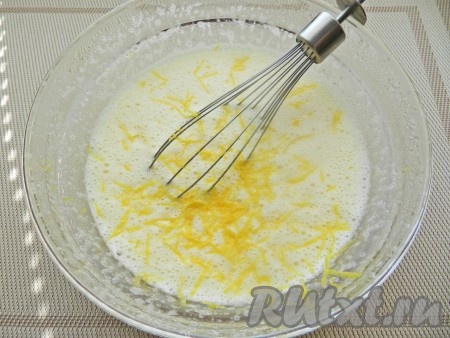 Яйца взбить с сахаром с помощью миксера в течение 5 минут (яичная масса увеличится в объёме и посветлеет). Лимон тщательно вымыть, затем снять с него цедру, стараясь не затрагивать расположенный под ней белый слой. В получившуюся яичную смесь добавить йогурт и цедру лимона, перемешать до однородности.