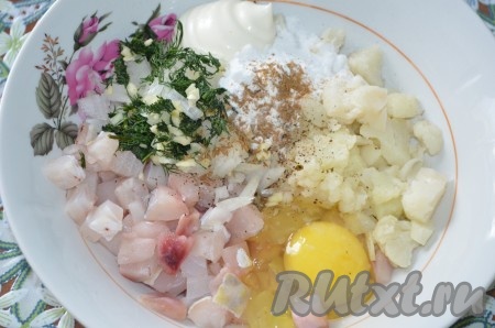 Сложить в миску рыбу, капусту, лук, чеснок, зелень, добавить сметану, яйцо, крахмал, специи, посолить.