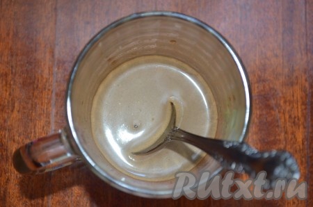 В небольшую ёмкость всыпать растворимый кофе, влить горячее молоко, тщательно перемешать, чтобы кофе растворилось.