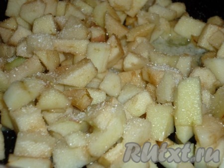 Тем временем приготовить начинку: яблоки помыть, очистить и порезать мелкими кубиками. Отправить на сковороду вместе со сливочным маслом и сахаром. 
