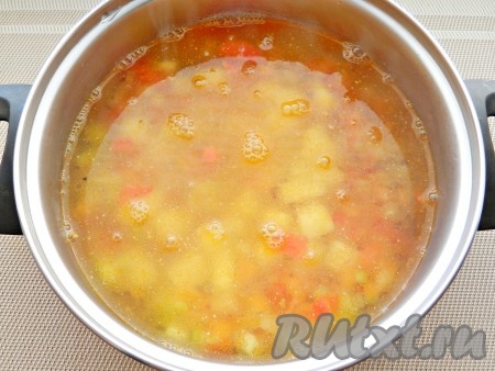 Влить процеженный рыбный бульон и поставить на огонь. Варить овощной суп с рыбой до готовности картофеля. 