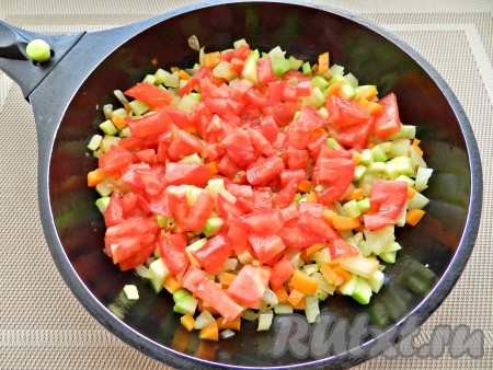 Нарезать помидор кубиками и выложить к остальным овощам. Готовить еще 5 минут, посолить и поперчить в процессе.
