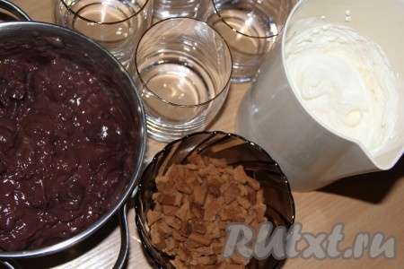 Шоколадный пудинг приготовить в соответствии с указаниями на упаковке и немного охладить. Поломать или раскрошить шоколадное печенье. Взбить до устойчивых пиков сливки с сахарной пудрой. 
