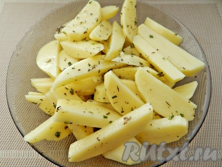Картофель нарезать крупными дольками и смешать с маслом и травами.