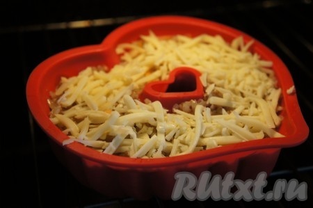 Отправить запеканку из гречки с овощами в разогретую духовку и запекать при 180 градусах до образования румяной сырной корочки.
