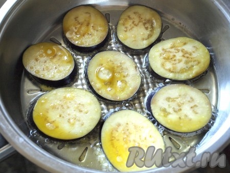 В сковороде разогреть подсолнечное масло. Каждый кружок баклажана окунать в яйцо с двух сторон и выкладывать на сковороду.