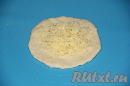 Каждую часть теста разделить на две части и раскатать скалкой в лепёшки. На одну лепёшку выложить сыр, примерно 1 столовую ложку.
