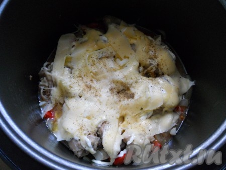 Далее, с помощью овощечистки, нарезать твердый сыр тонкими слайсами и посыпать ими сверху курицу, добавить порезанный небольшими кусочками чеснок, поперчить.  Выставить режим мультиварки "Выпечка" на 45 минут.
