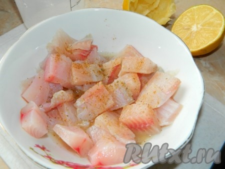 Тесто разморозить. Порезать филе рыбы на небольшие кусочки, посолить, поперчить и замариновать в соке лимона.
