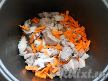 Лук и морковь очистить. Луковицу нарезать на небольшие кусочки, морковку - на брусочки. После того как кусочки свинины обжарятся в течение 15 минут, добавить морковку с луком в чашу мультиварки. Обжаривать мясо с овощами на режиме "Жарка" 15 минут, периодически помешивая.