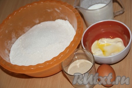 Приготовим тесто: разводим дрожжи в тёплой воде, добавляем 1 столовую ложку сахара, перемешиваем и оставляем опару на 10-15 минут в тепле, чтобы дрожжи ожили. Маргарин растапливаем и остужаем. Кефир слегка подогреваем. Просеянную муку смешиваем с сахаром и солью.
