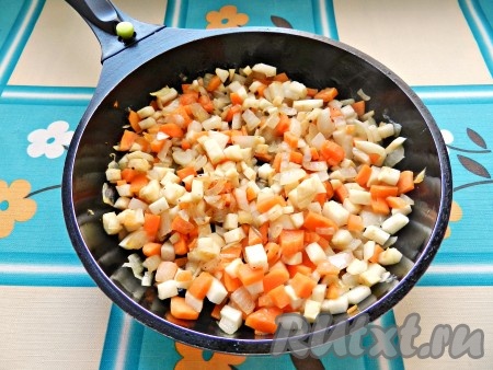 В сковороде разогреть растительное масло. Обжарить сначала лук до прозрачности, затем добавить морковь, корень сельдерея и обжарить все вместе до легкого золотистого цвета. Посолить и поперчить.
