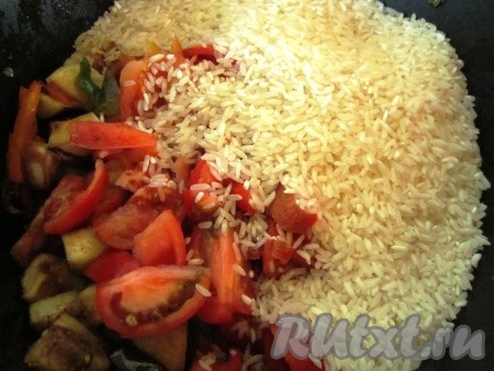 Затем выложить на овощи сухой рис и помидоры.