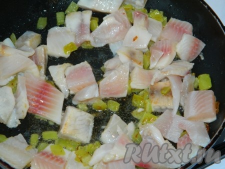 Рыбное филе режем кубиками, добавляем на сковороду и готовим несколько минут, периодически помешивая.
