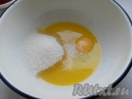 Сливочное масло растопить, обязательно остудить до тёплого состояния, перелить в объёмную миску, добавить сырое яйцо, соль и оставшийся сахар, перемешать.