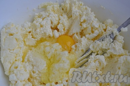 К творогу добавить сахар и крахмал, перемешать и по одному добавлять яйца, хорошо взбивая массу.
