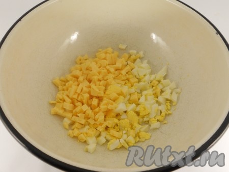 Яйца отварить вкрутую, очистить и нарезать небольшими кусочками. Добавить порезанный мелкими кубиками твердый сыр.
