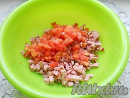 Колбасу порезать мелкими кубиками, добавить также порезанный свежий помидор.