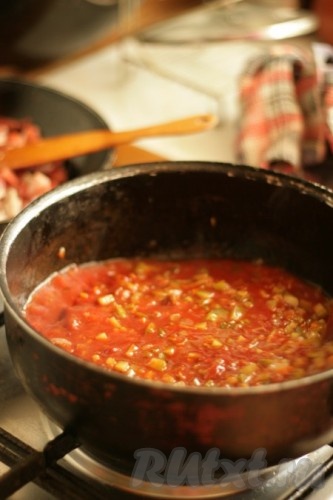 Добавить рассол и томатную пасту к обжаренным овощам, довести до кипения и положить в бульон.

