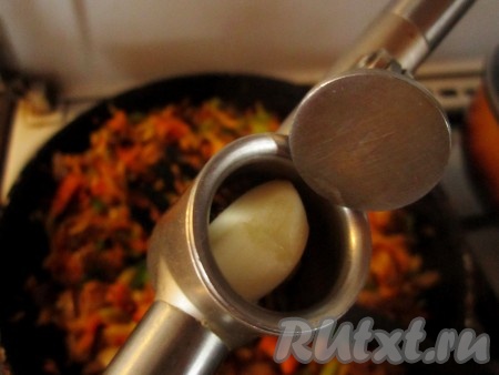 Чеснок очистите и выдавите через пресс в сковороду с овощами. Снимите овощи с огня.