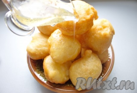 Готовые греческие пончики "Лукумадес" выложить на блюдо и полить горячим медовым сиропом. Часть сиропа можно оставить для подачи.

