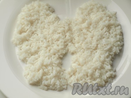 Выложить на блюдо рис в форме рукавичек, разровнять и немного смазать майонезом.