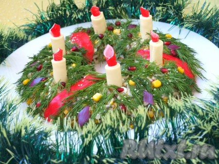 Верх салата "Рождественский венок" украшаем веточками укропа, гранатовыми зёрнами, кукурузой и кунжутом. Из фиолетового лука тоже можно вырезать ромбики. Ленты изготавливаем из красной части крабовых палочек. В общем, оформляем, как подскажет ваша фантазия. Такой салат станет украшением стола и создаст праздничную атмосферу.

