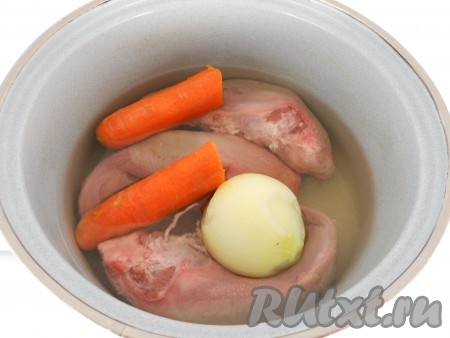 Поместить в глубокую кастрюлю вместе с очищенной луковицей и морковью, залить водой.