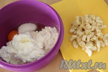 В миске соединить творог, яйцо, сахар и муку. Всё хорошо перемешать. Банан почистить и нарезать на небольшие кусочки.