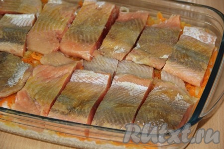 Горбушу нарезать на порционные кусочки, посолить и поперчить по вкусу. Выложить рыбу поверх риса и овощей.
