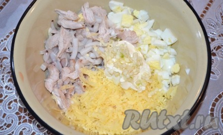 В миску сложить кальмаров, курицу, сыр, яйца, выдавить чеснок. Посолить и поперчить салат по вкусу, заправить сметаной, майонезом или натуральным йогуртом.
