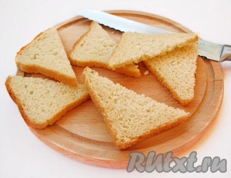 Нарежьте хлеб небольшими ломтиками. Празднично будут смотреться треугольники из хлеба. Намного проще, если купить хлеб уже нарезной. И черный, и белый - подходят для таких бутербродов (можно сделать часть их из черного и часть - из белого хлеба).
