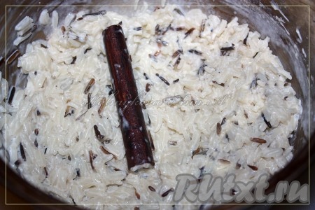 Добавить в горячее молоко рис и варить до готовности на медленном огне, в итоге получается рисовая каша. По окончанию варки изъять палочку корицы.
