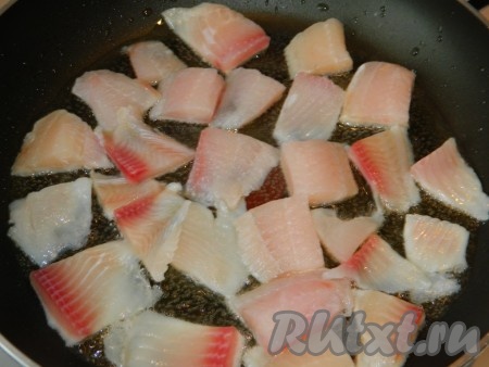 Филе рыбы режем на кусочки. На разогретую сковороду наливаем растительное масло, выкладываем кусочки рыбы и в течение нескольких минут обжариваем с одной стороны до золотистой корочки.

