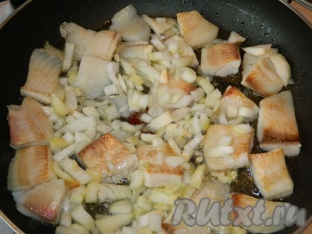Затем рыбку переворачиваем, добавляем порезанный лук и слегка обжариваем. 
