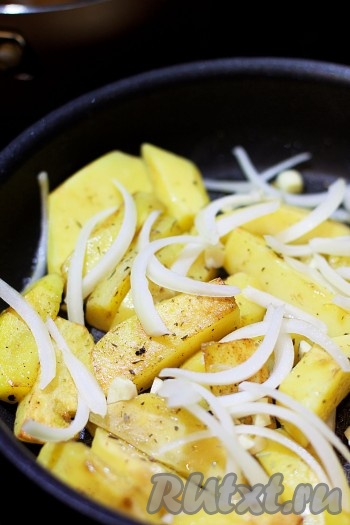 Нарежьте чеснок небольшими дольками, а лук - полукольцами. Добавьте овощи в сковороду к картофелю. 
